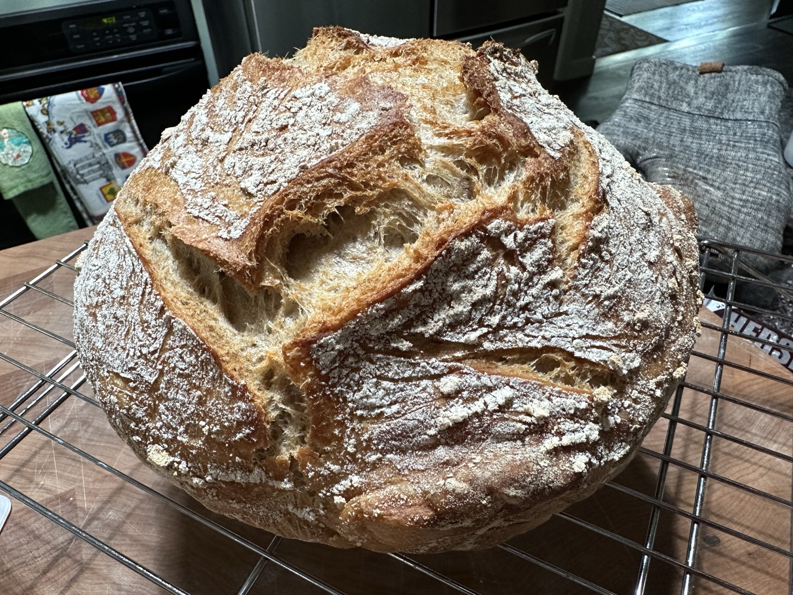 A close up of the very textured crust of a round loaf of bread fresh from the oven.